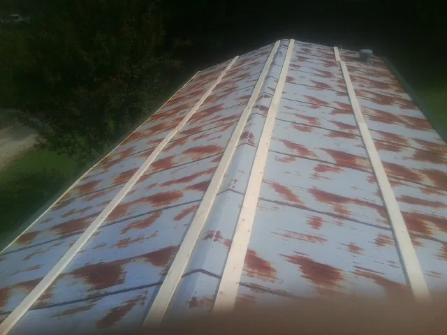 Rusted metal roof panels with new wood purlins before replacement — Storm Damage Roof Repair in Raynham by Roofing Brothers