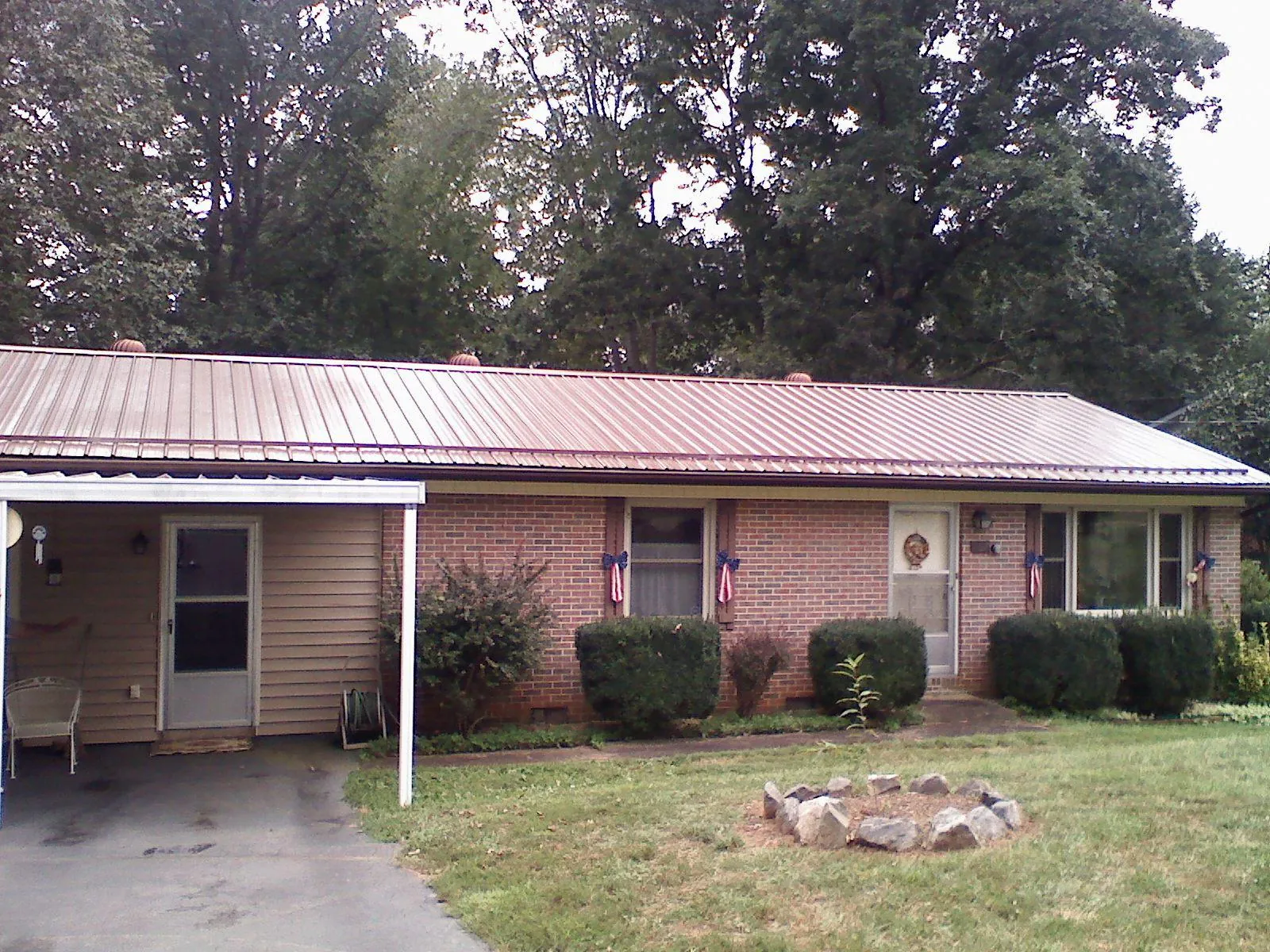 Bronze metal roof and carport on a brick ranch home — Roof Repair work by our crew in Raynham